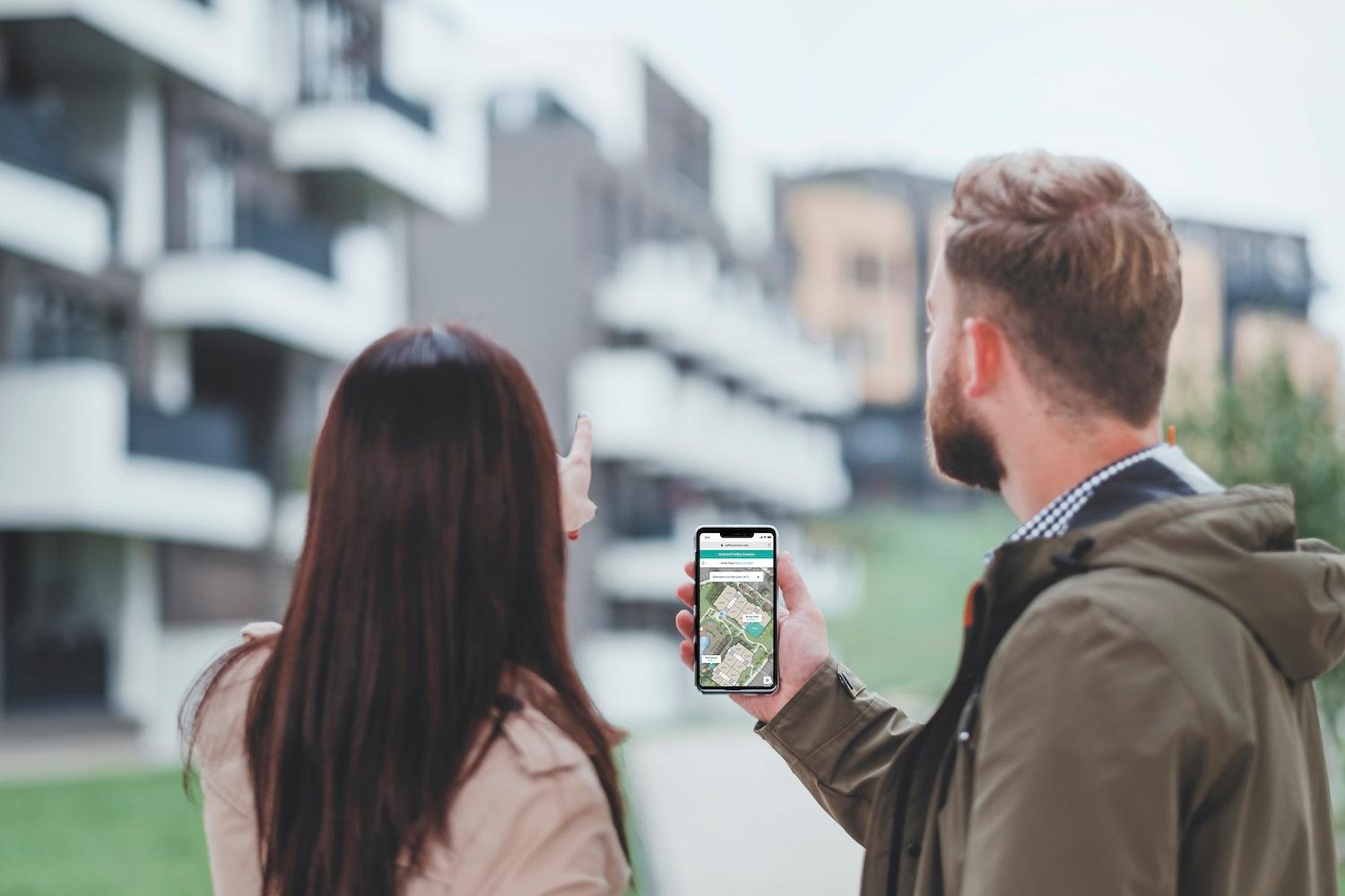 Two prospective residents use a self-guided touring app while touring an apartment community.