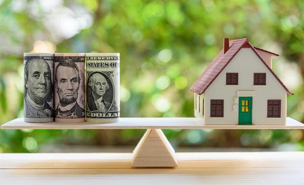 money and house balancing on teeter totter