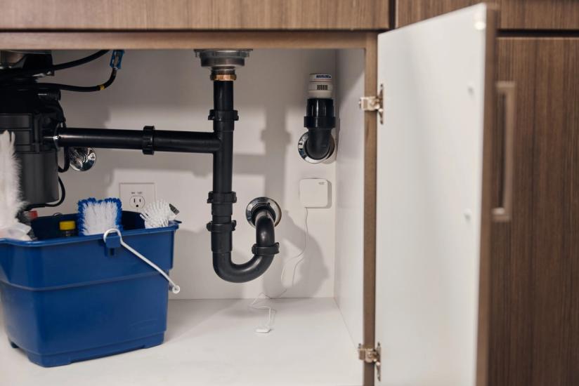 SmartRent leak sensor installed under sink in an apartment
