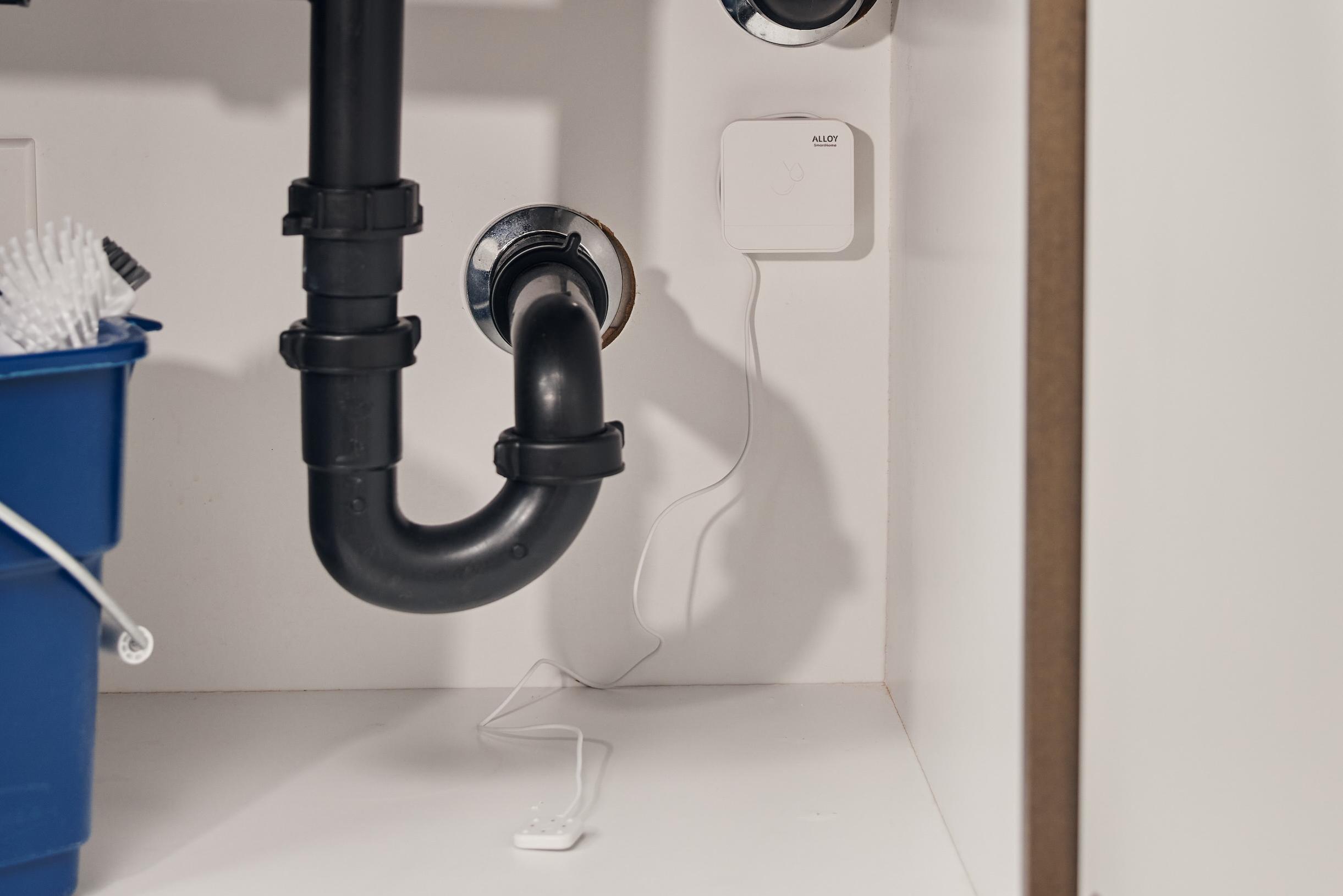 Image of maintenance placing a leak sensor in a laundry room