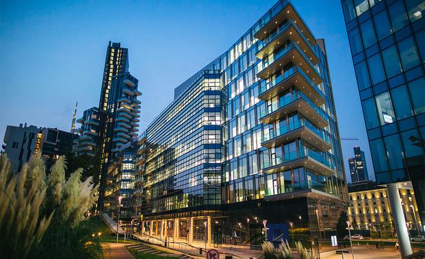 city apartment high rise building lit up at dusk