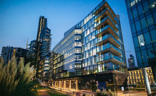 city apartment high rise building lit up at dusk