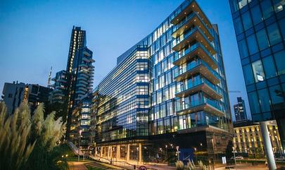 city apartment high rise building lit up at dusk