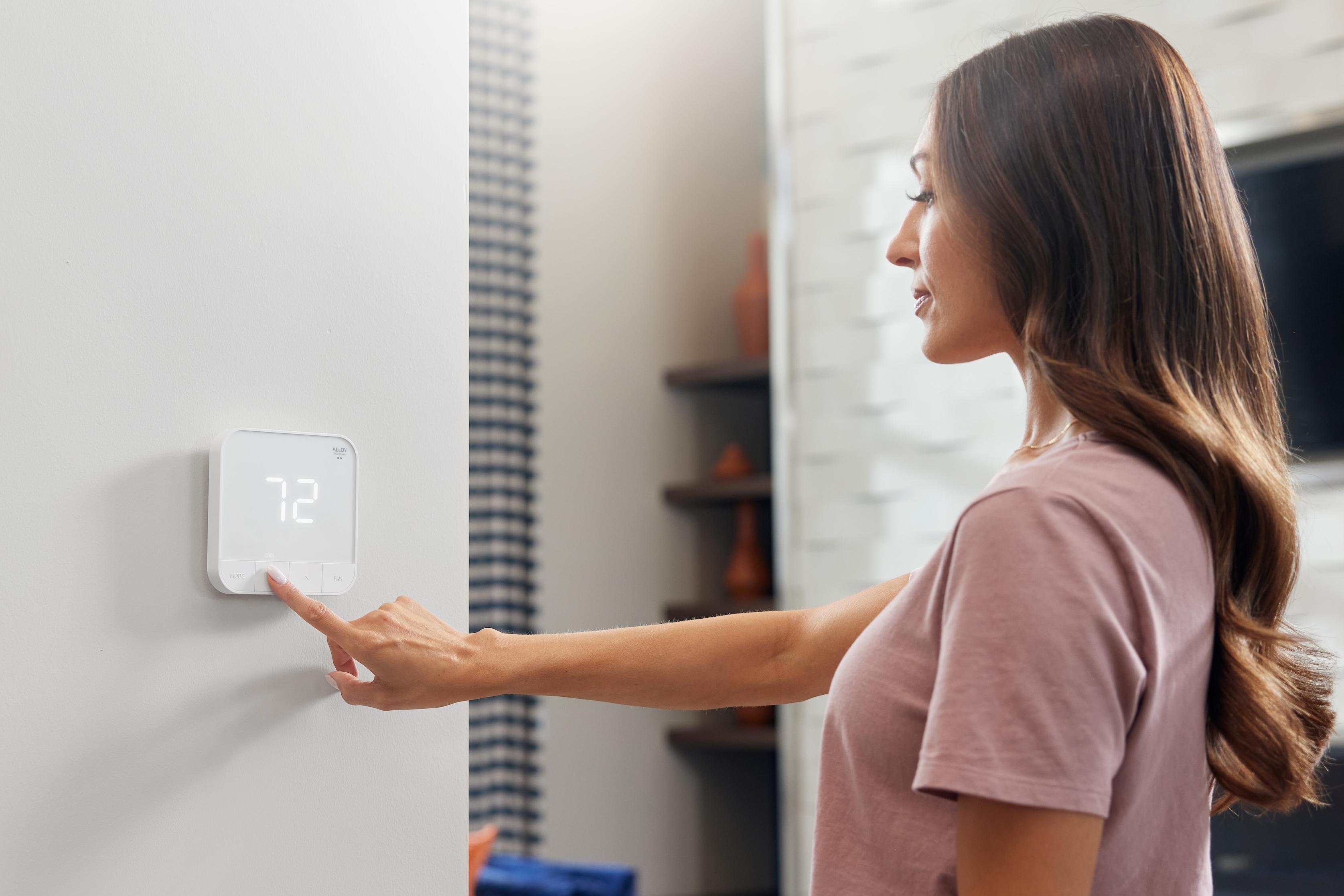 Woman adjusting Smart Apartment controls at a hub in her home
