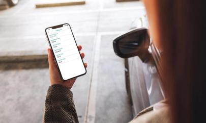 SmartRent user holds a smartphone with parking information displayed on the screen.