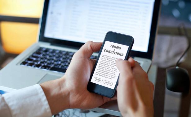 Person holding phone reading terms and conditions of a vendor agreement