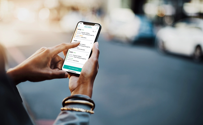 person holding phone using SmartRent Community Manager app