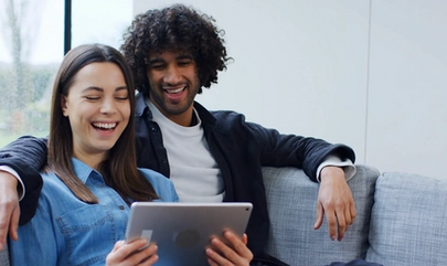 Couple sitting on couch looking at iPad