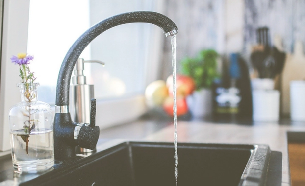 Image of a kitchen faucet with running water