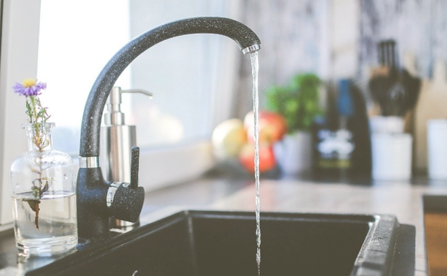 Image of a kitchen faucet with running water