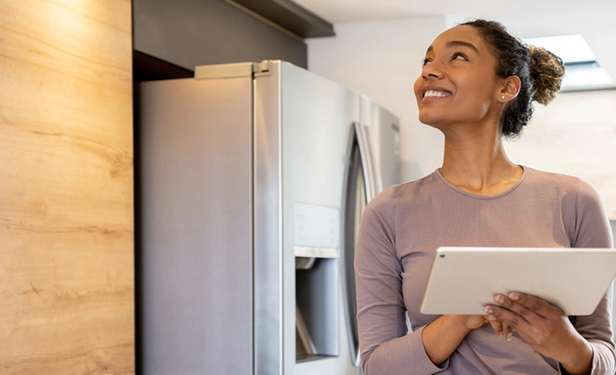 Young adult operates a smart home using a tablet.