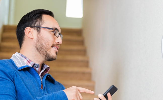 Resident uses smartphone to control a thermostat. 